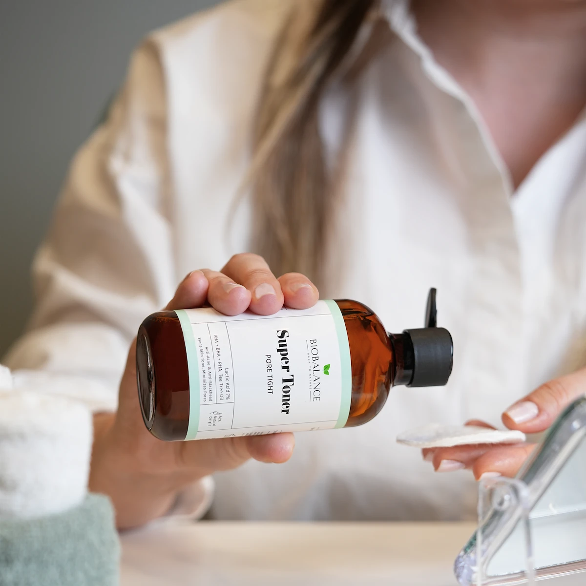 Girl applying BioBalance Super Toner onto a cotton pad